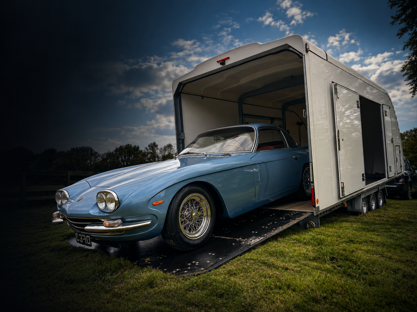 Classic car being loaded into an enclosed transport trailer